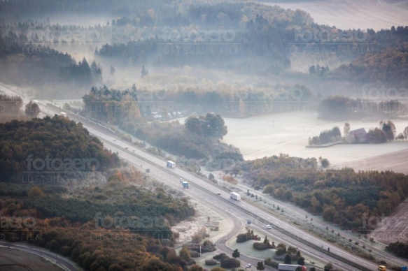 Eine Autobahn umhÃ¼llt in eine Nebeldecke.